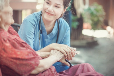 Nurse holding woman's hand.