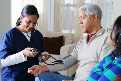 Woman taking elderly man's pulse